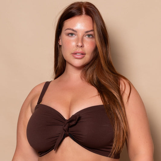 plussize woman wearing a chocolate brown bikini set against a beige background