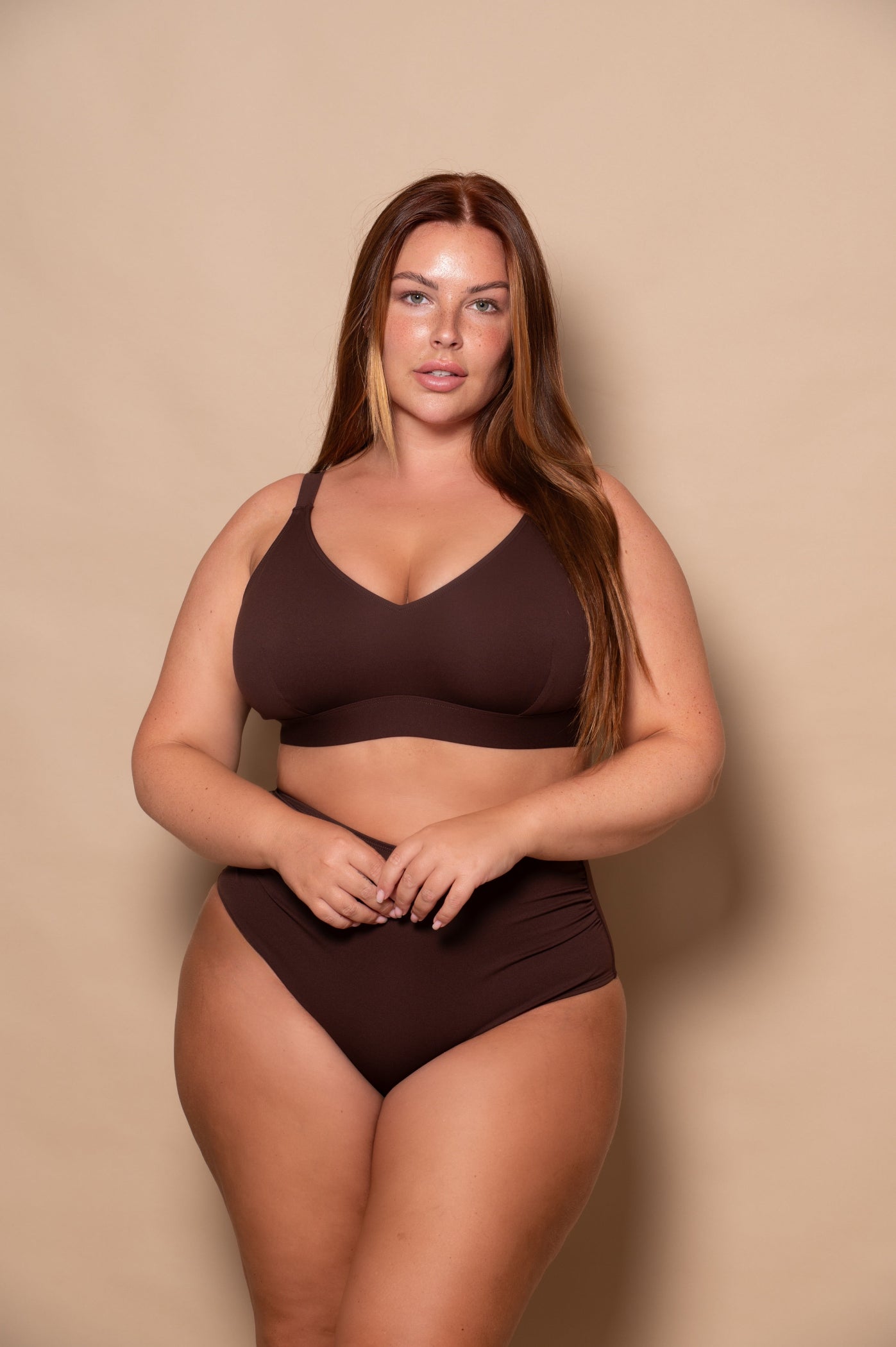curvy woman wearing a brown bikini set against a beige background
