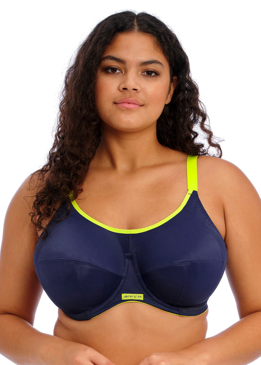 curvy woman wearing a plussize sportsbra in navy blue with accents in lime color