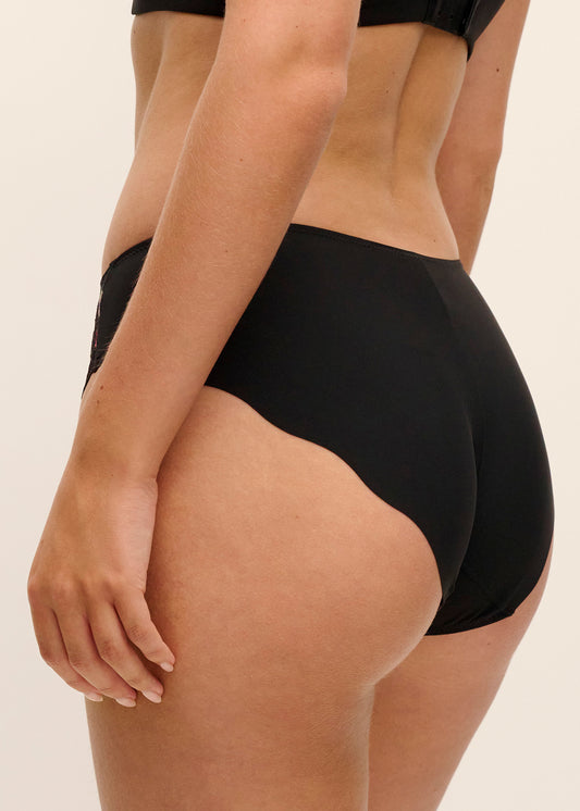 woman wearing a black brief with lace and floral embroidery in sunset colors