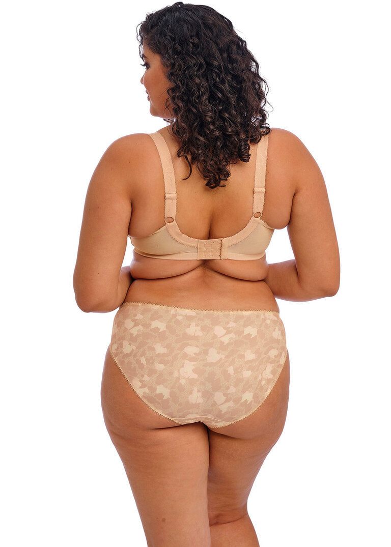 curvy woman wearing a big cup bra in beige with subtile leaves print and stretch lace