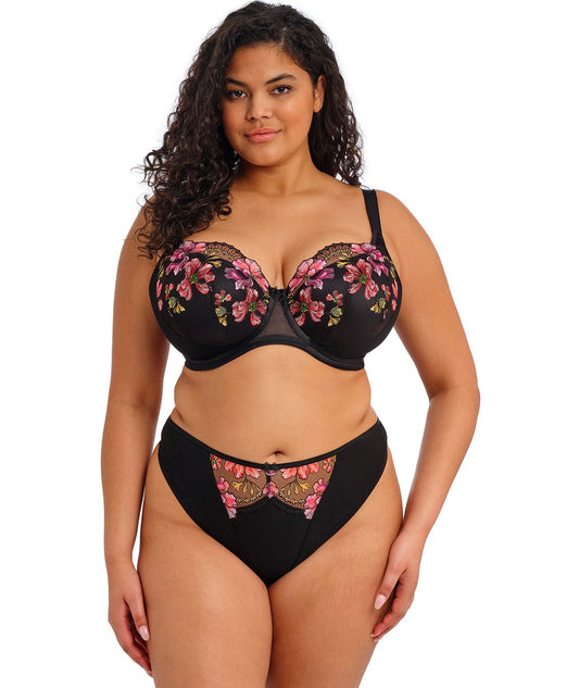 woman wearing a black padded big cup bra with lace and embroidered flowers in summer colours
