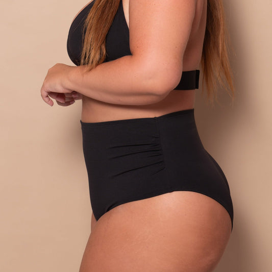 curvy woman wearing a black bikini against a beige background