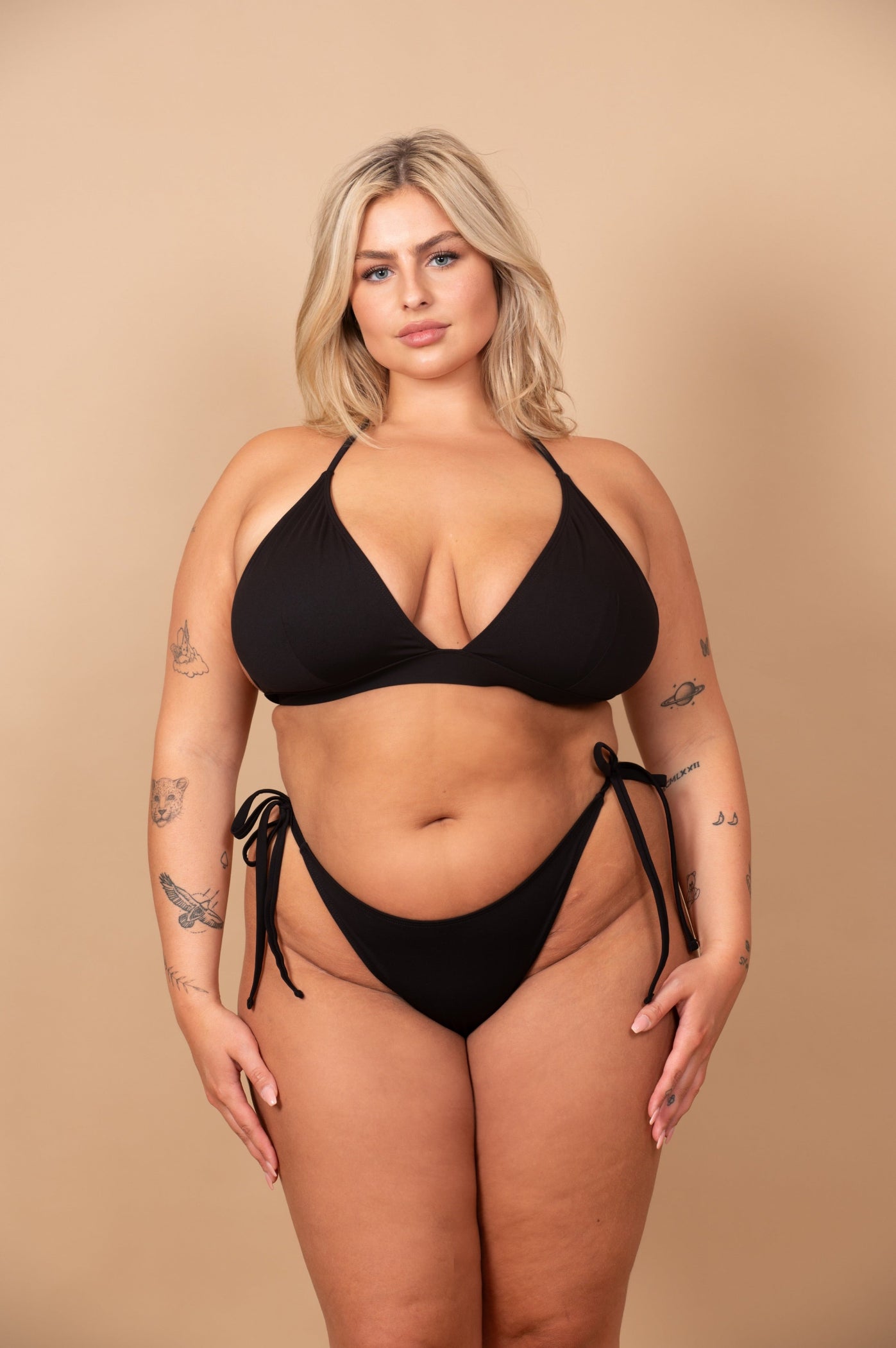 curvy woman wearing a black bikini against a beige background