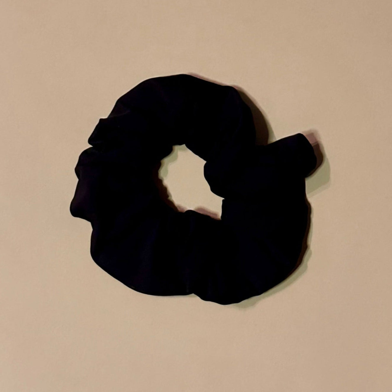 Black scrunchie on a beige background