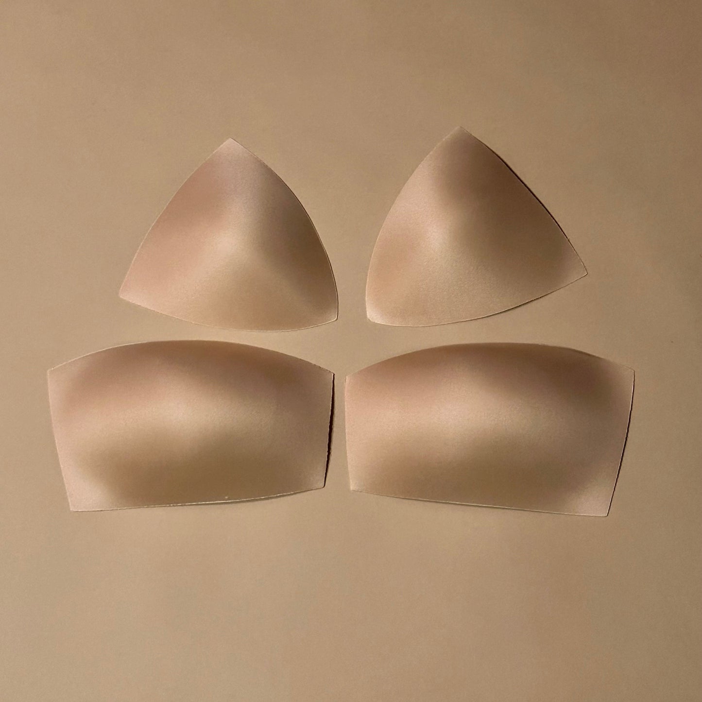 Set of beige bra cups or padding on a beige background
