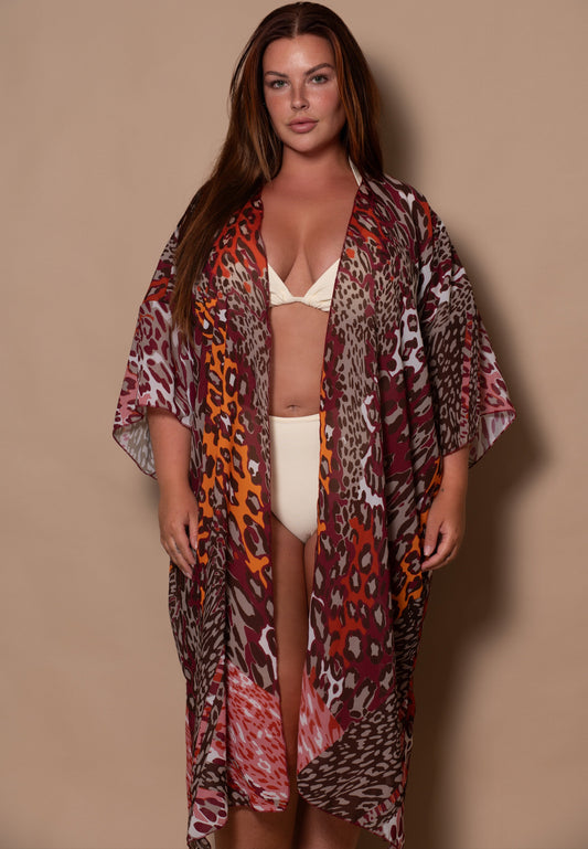 Woman wearing a patterned kimono over a bikini against a beige background