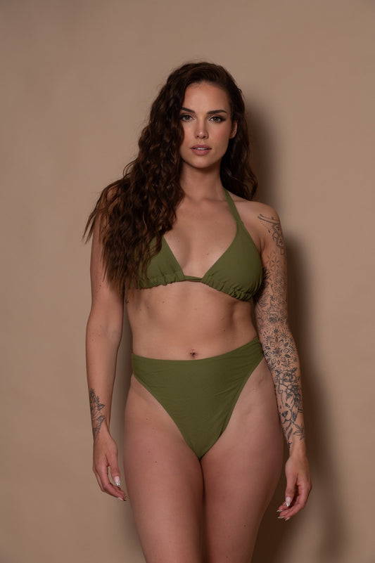 woman wearing a green khaki bikini set against a beige background