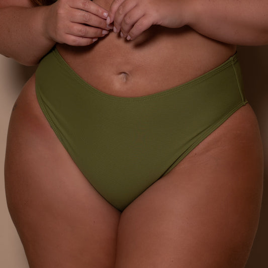 plussize woman wearing a khaki green bikini against a beige background