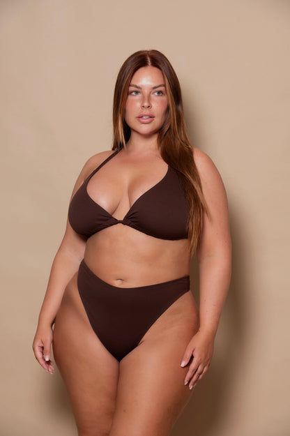plussize woman wearing a chocolate brown bikini set against a beige background