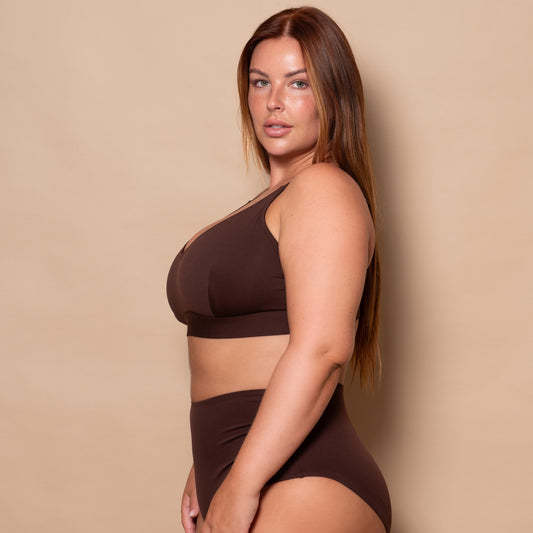 plussize woman wearing a chocolate brown bikini set against a beige background