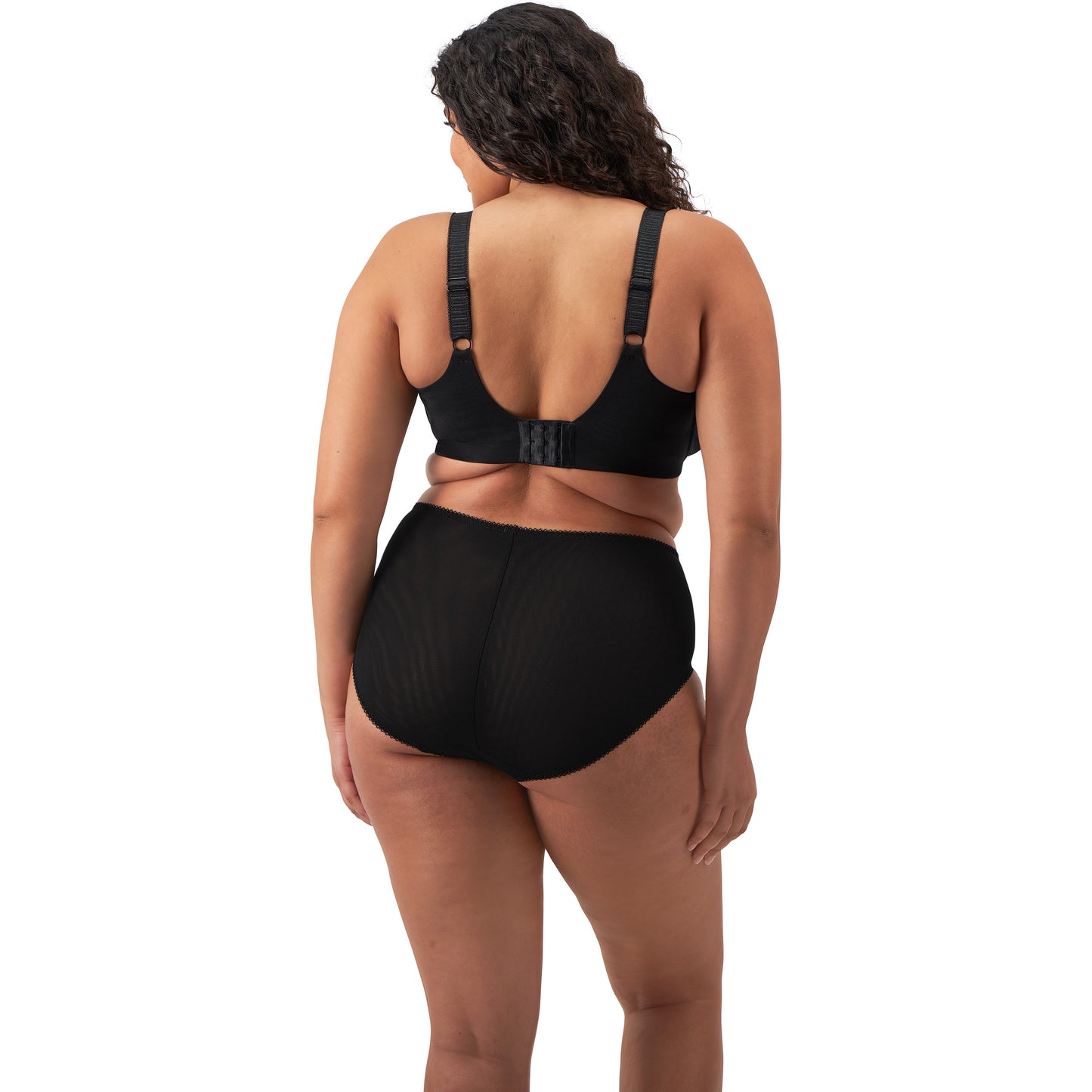 plussize woman wearing a black lingerie set against a white background