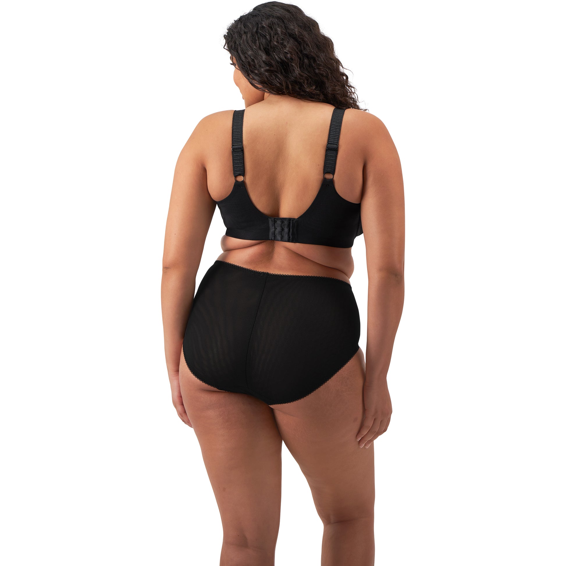 plussize woman wearing a black lingerie set against a white background