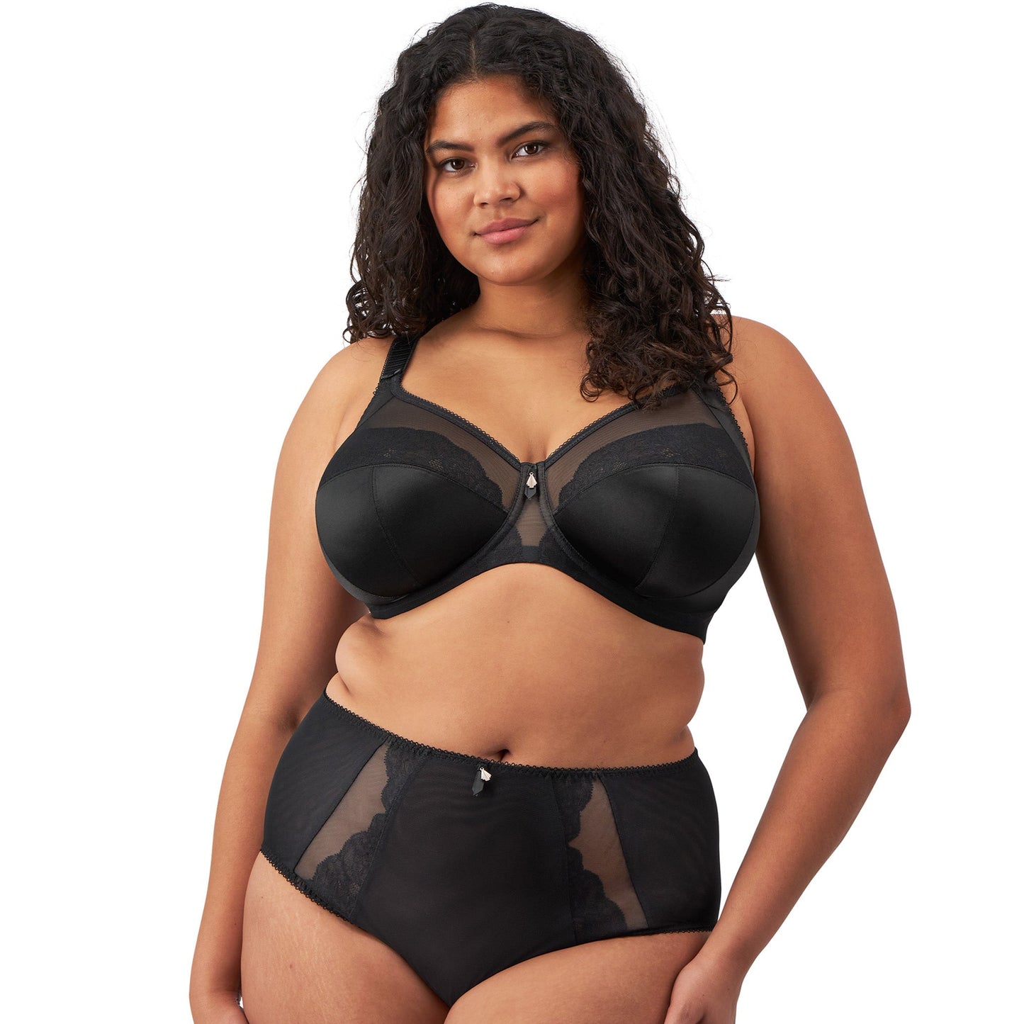 plussize woman wearing a black lingerie set against a white background