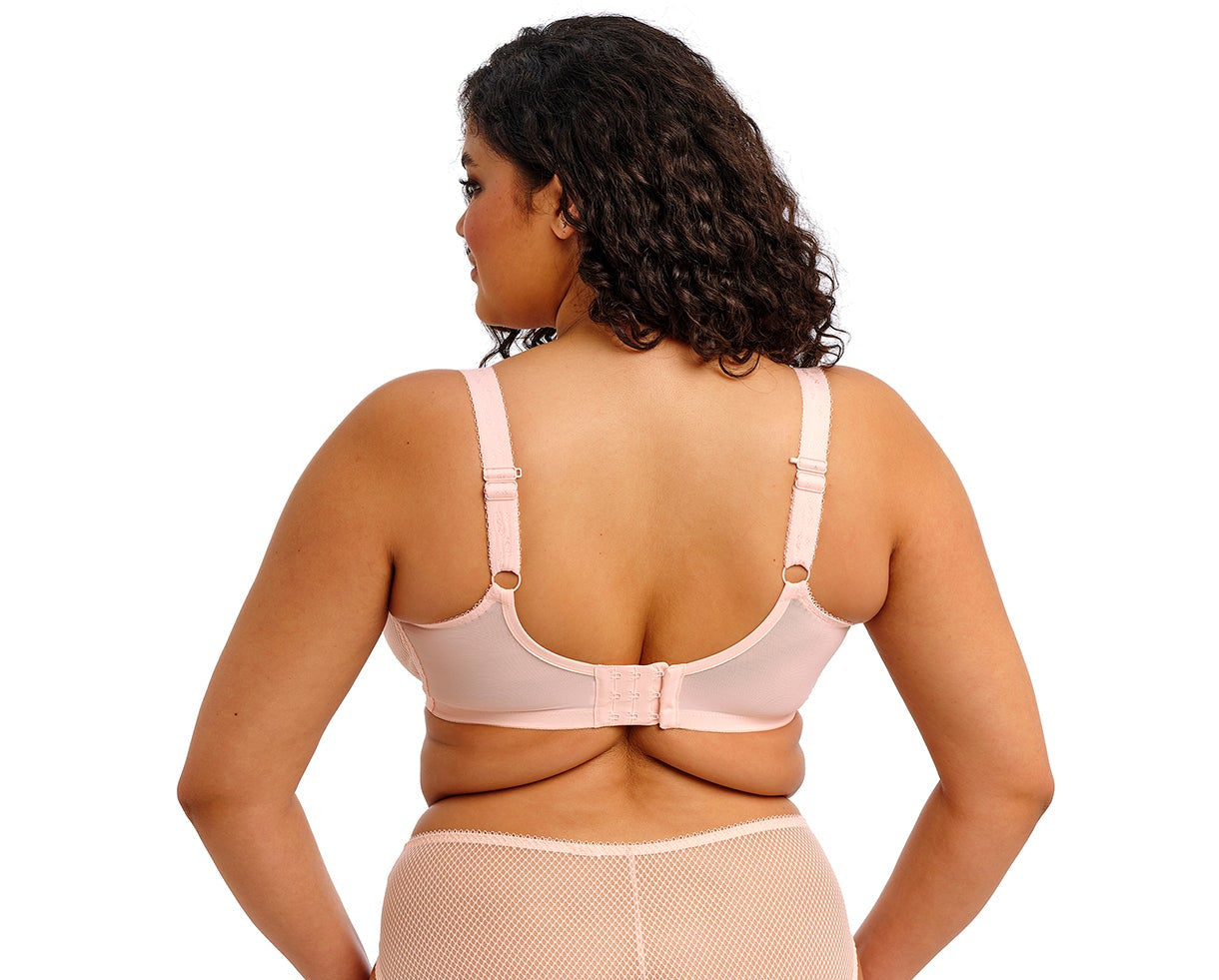 curvy woman wearing a big cup bra in pink lace with embroidered flowers