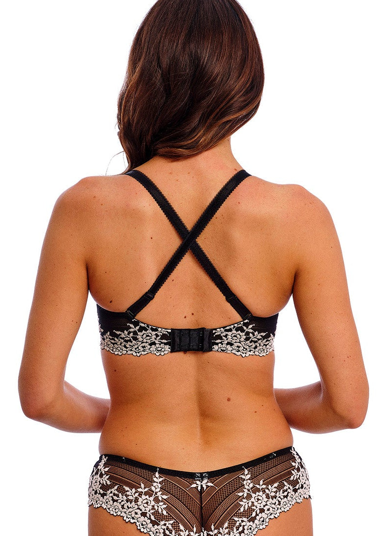 woman wearing a black lace plunge bra with flower details in ivory color