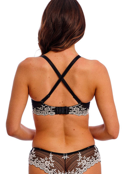 woman wearing a black lace plunge bra with flower details in ivory color