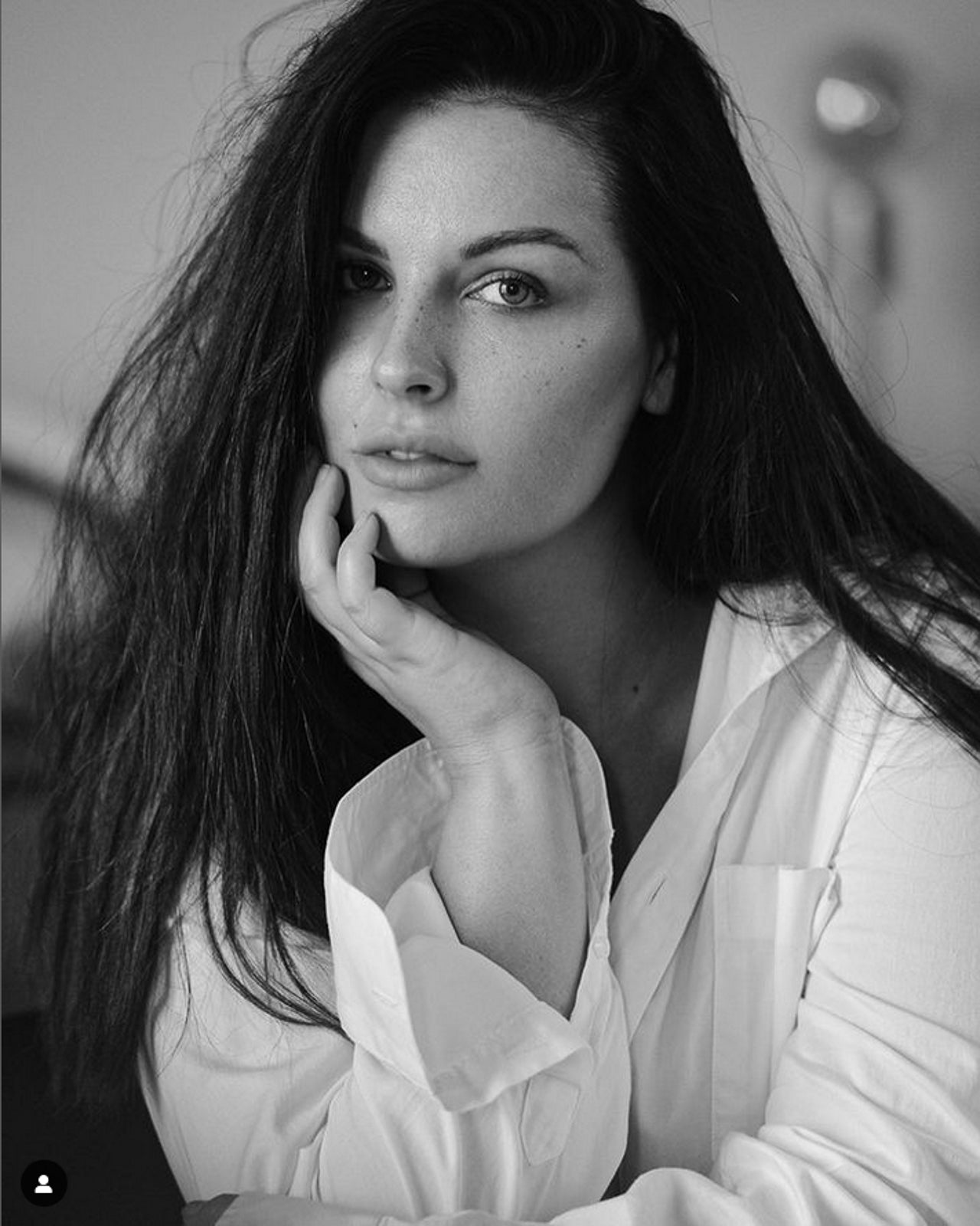Black and white portrait of a curvy woman wearing a white shirt.