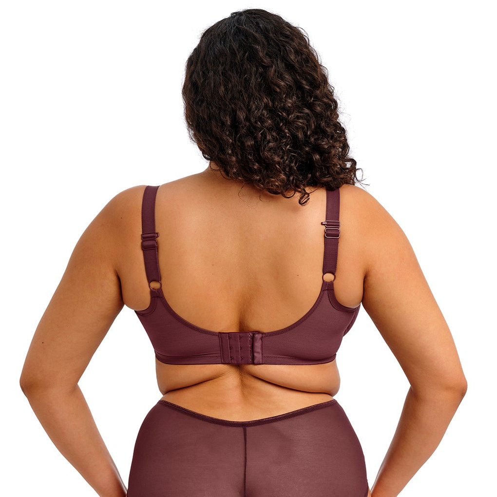 curvy woman wearing a purple lingerie set on a white background