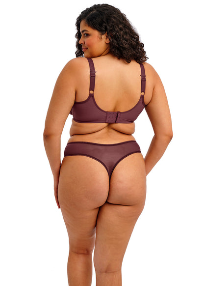 curvy woman wearing a purple lingerie set with lace trim on a white background