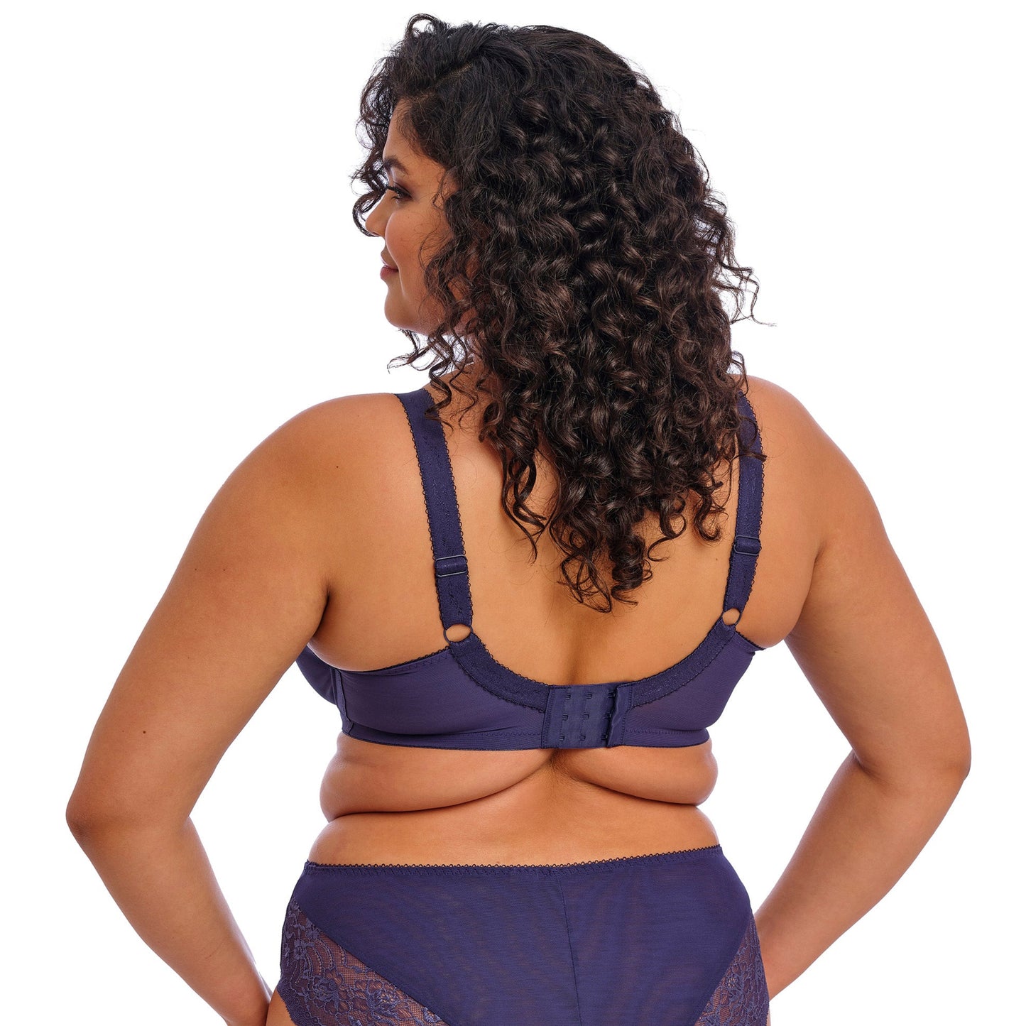 Curvy woman wearing a blue lingerie set on a white background