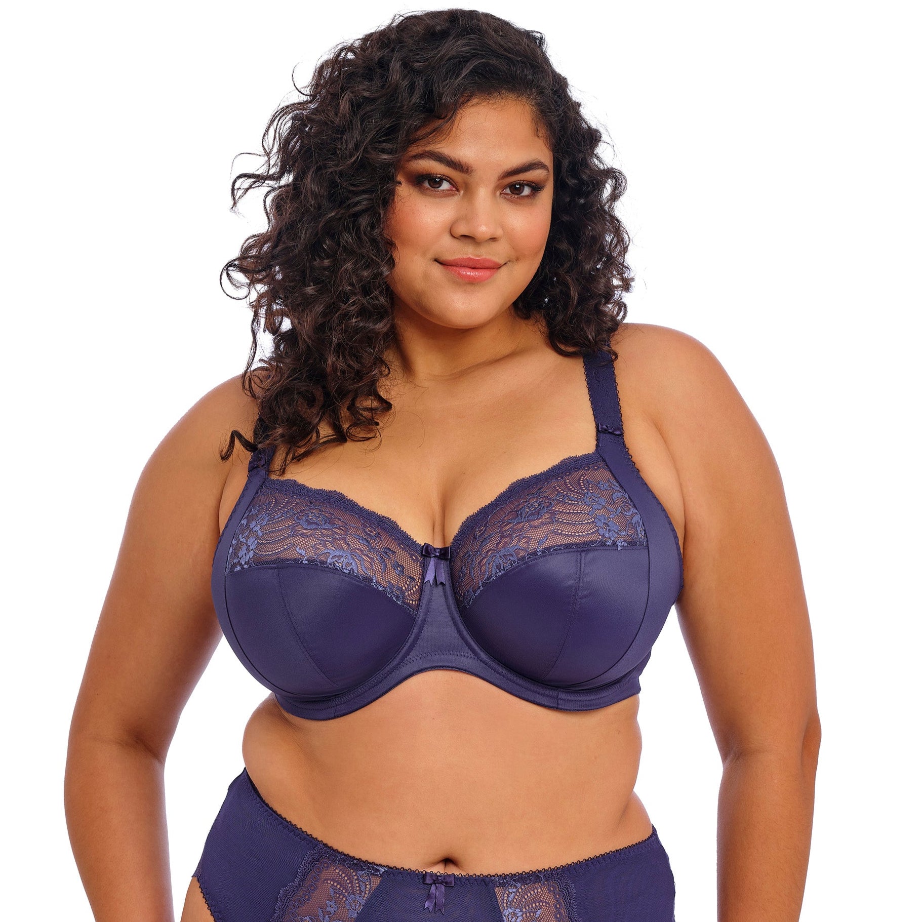 Curvy woman wearing a blue lingerie set on a white background