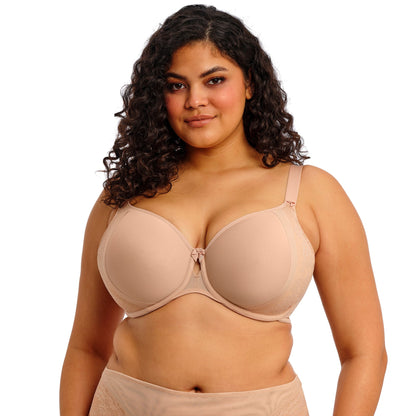 Curvy woman wearing beige lingerie against a white background