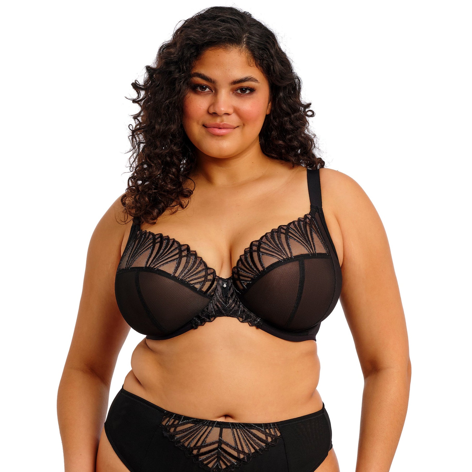 curvy woman wearing a black lace lingerie set against a white background