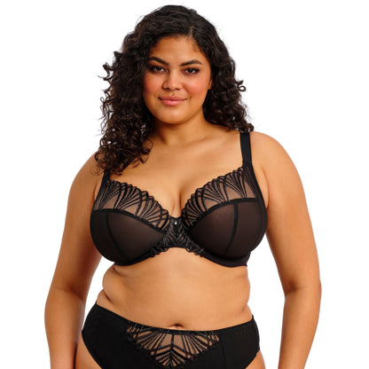 curvy woman wearing a black lace lingerie set against a white background