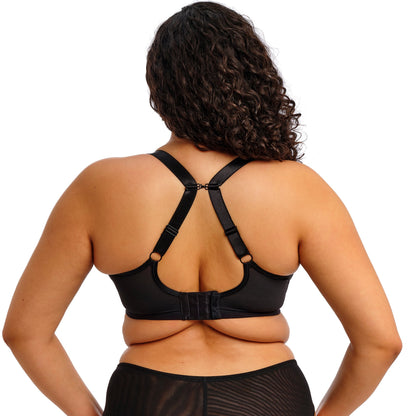 curvy woman wearing a black lace lingerie set against a white background