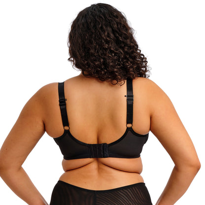 curvy woman wearing a black lace lingerie set against a white background