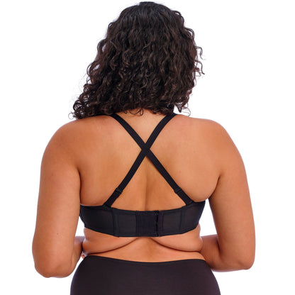 curvy woman wearing a black strapless bra on a white background