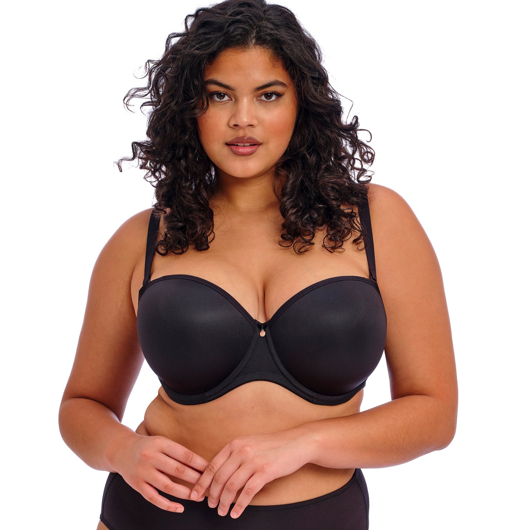 curvy woman wearing a black strapless bra on a white background