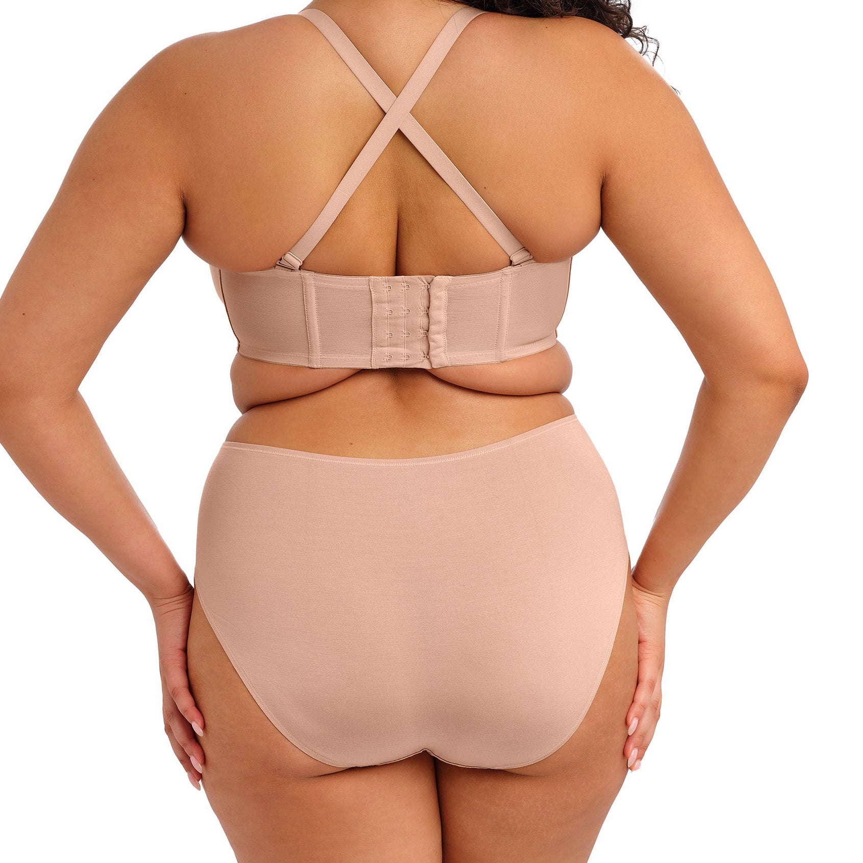 curvy woman wearing nude color  smooth lingerie briefs against a white background