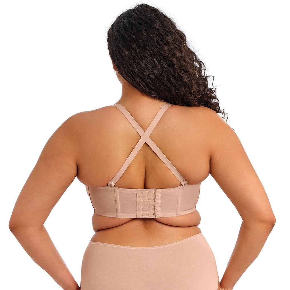 curvy woman wearing a beige strapless bra  against a white background