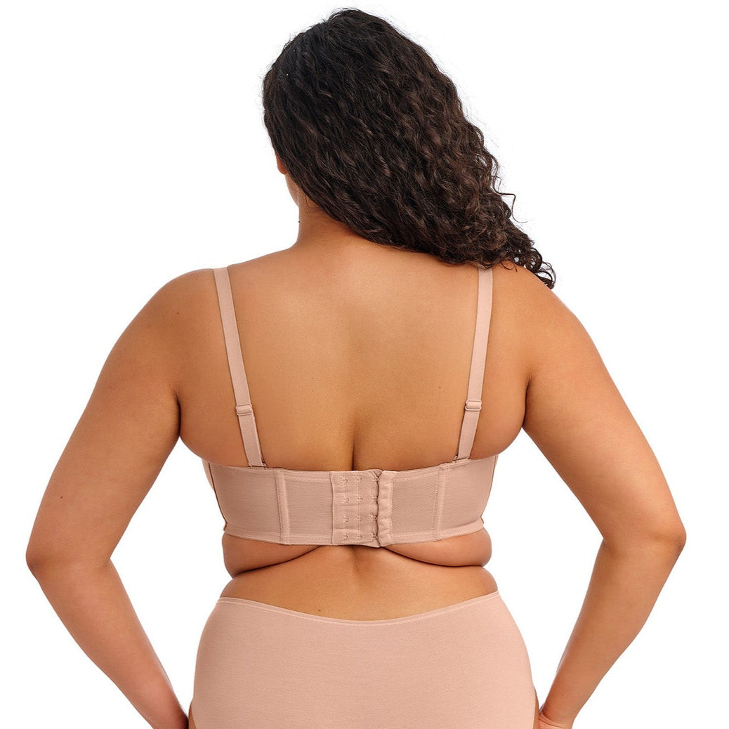 curvy woman wearing a beige strapless bra  against a white background