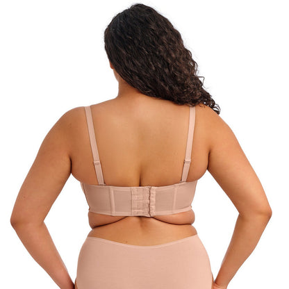curvy woman wearing a beige strapless bra  against a white background