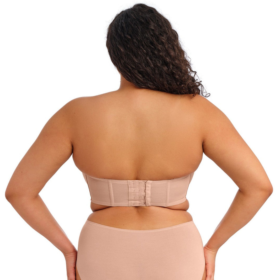 curvy woman wearing a beige strapless bra  against a white background