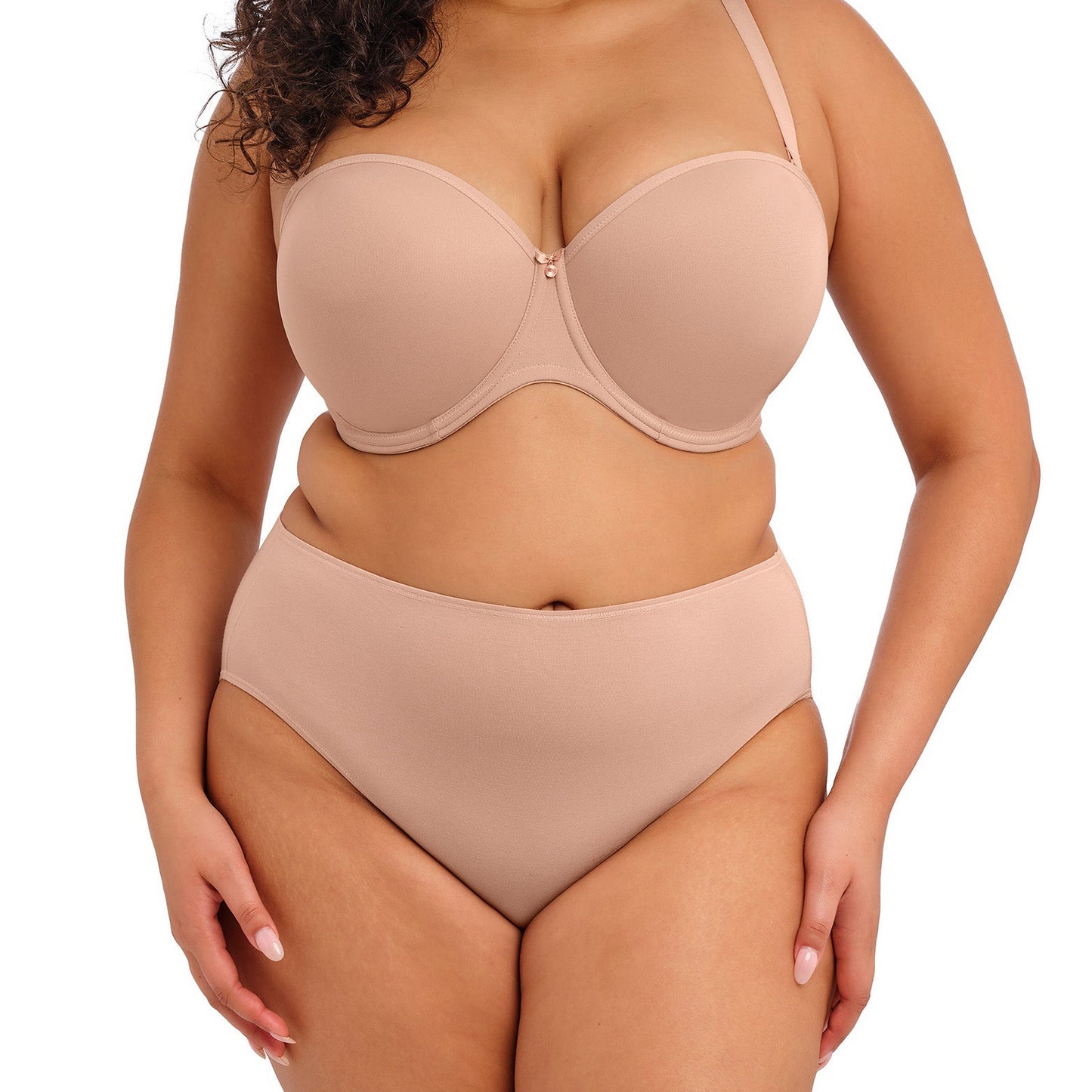 curvy woman wearing nude color  smooth lingerie briefs against a white background