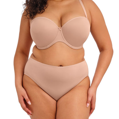 curvy woman wearing nude color  smooth lingerie briefs against a white background