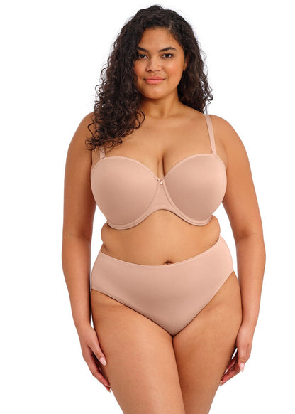 curvy woman wearing a beige strapless bra  against a white background