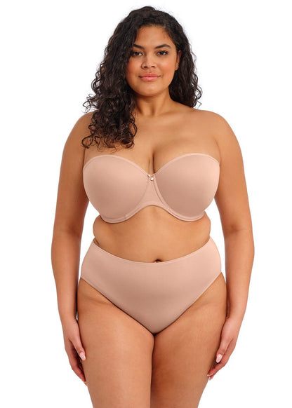 curvy woman wearing a beige strapless bra  against a white background