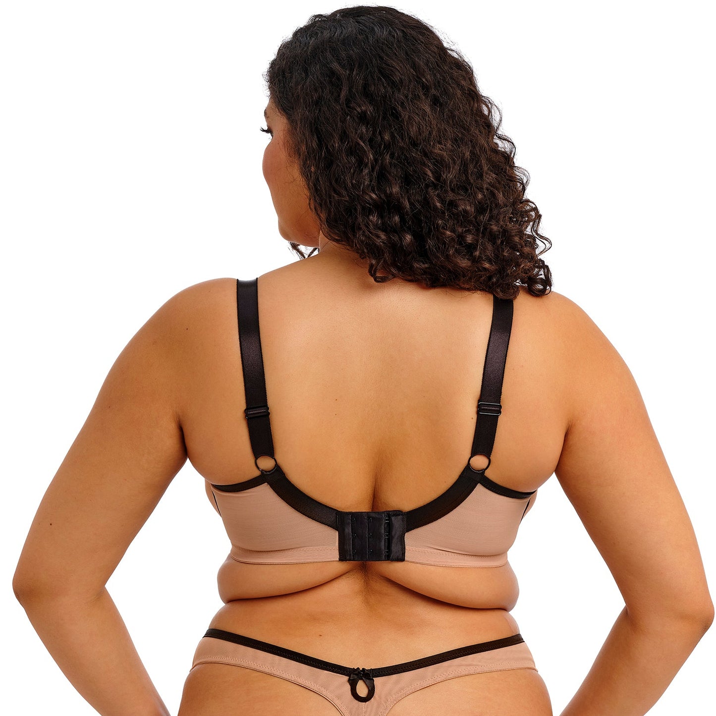 curvy Woman wearing a beige and black lace lingerie set on a white background