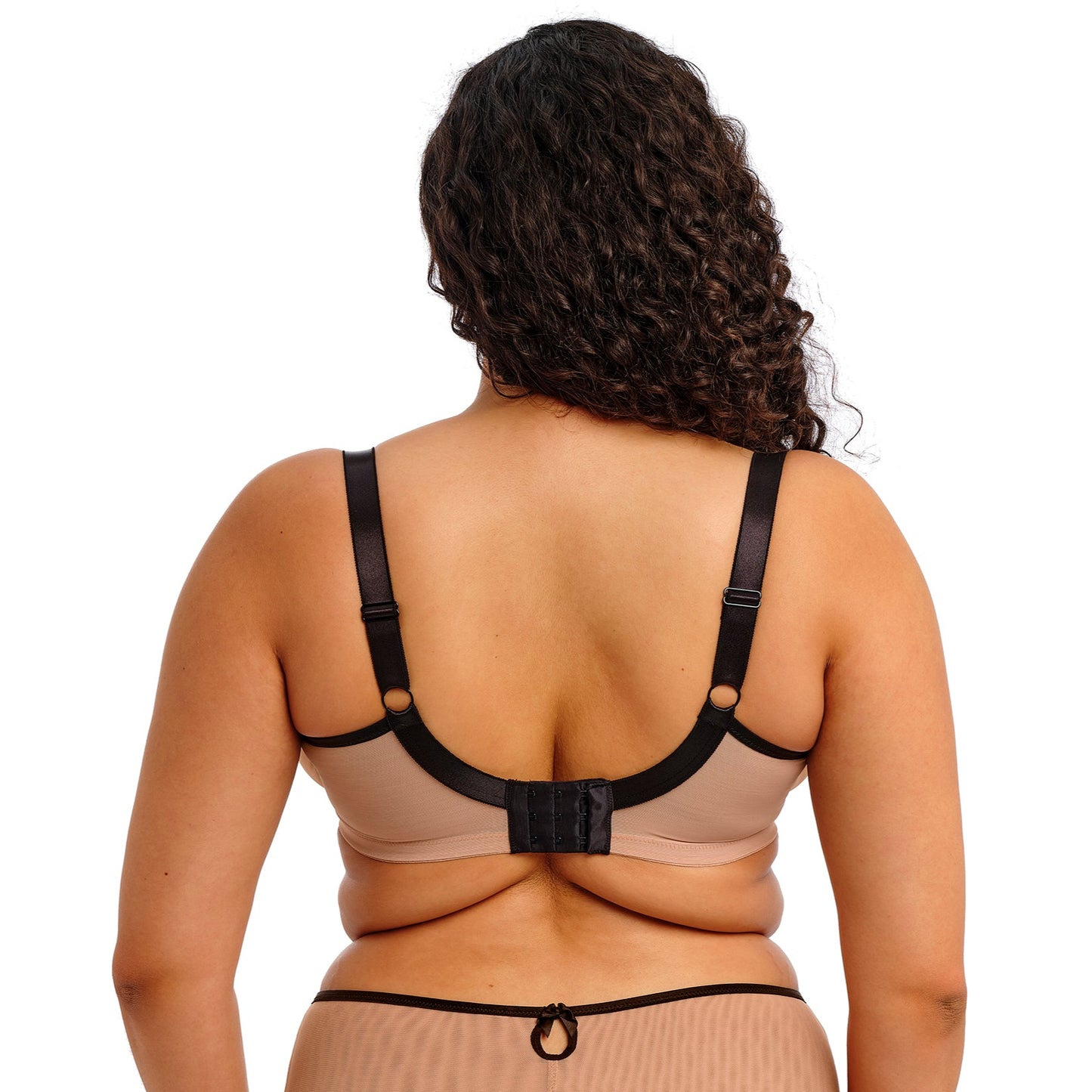 curvy woman wearing a beige lingerie set with black straps and black lace on a white background