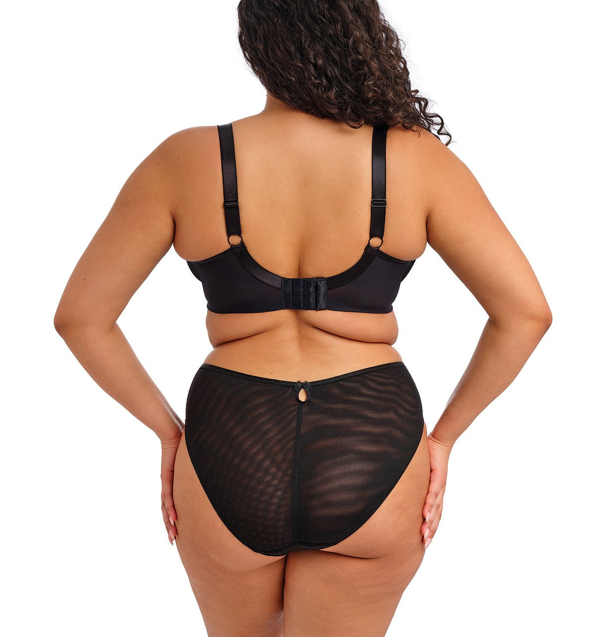 curvy woman wearing a black high leg brief with lace and embroidered flower details in summer colours