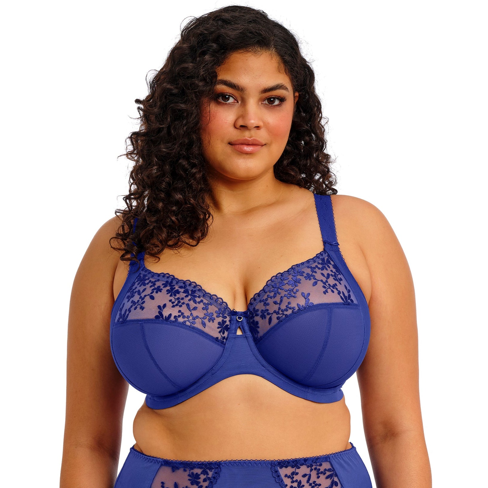 curvy woman wearing a Sapphire blue bra with floral lace details on a white background