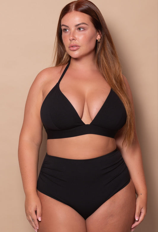 curvy woman wearing a black bikini against a beige background