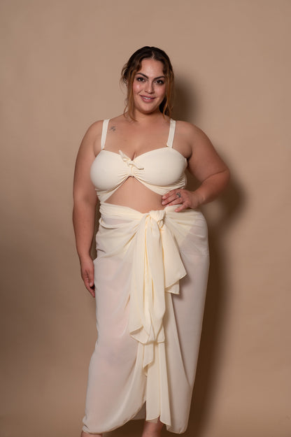 plussize woman wearing a white cream bikini against a beige background
