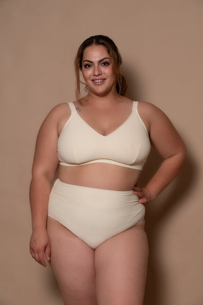 curvy woman wearing a cream - white  bikini against a beige background