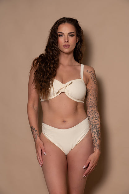 woman wearing a white bikini against a beige background